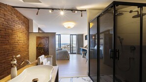 A modern bathroom with a large sink, a glass shower enclosure, and a view of the city. - Sublime Porte Hotel (Istanbul)