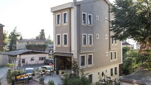 A multi-story building with a courtyard featuring outdoor seating and potted plants. - Sublime Porte Hotel (Istanbul)