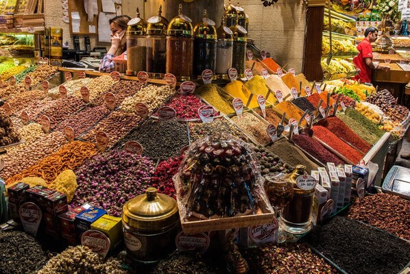 Un mercado de especias con una variedad de condimentos expuestos a granel y en frascos.