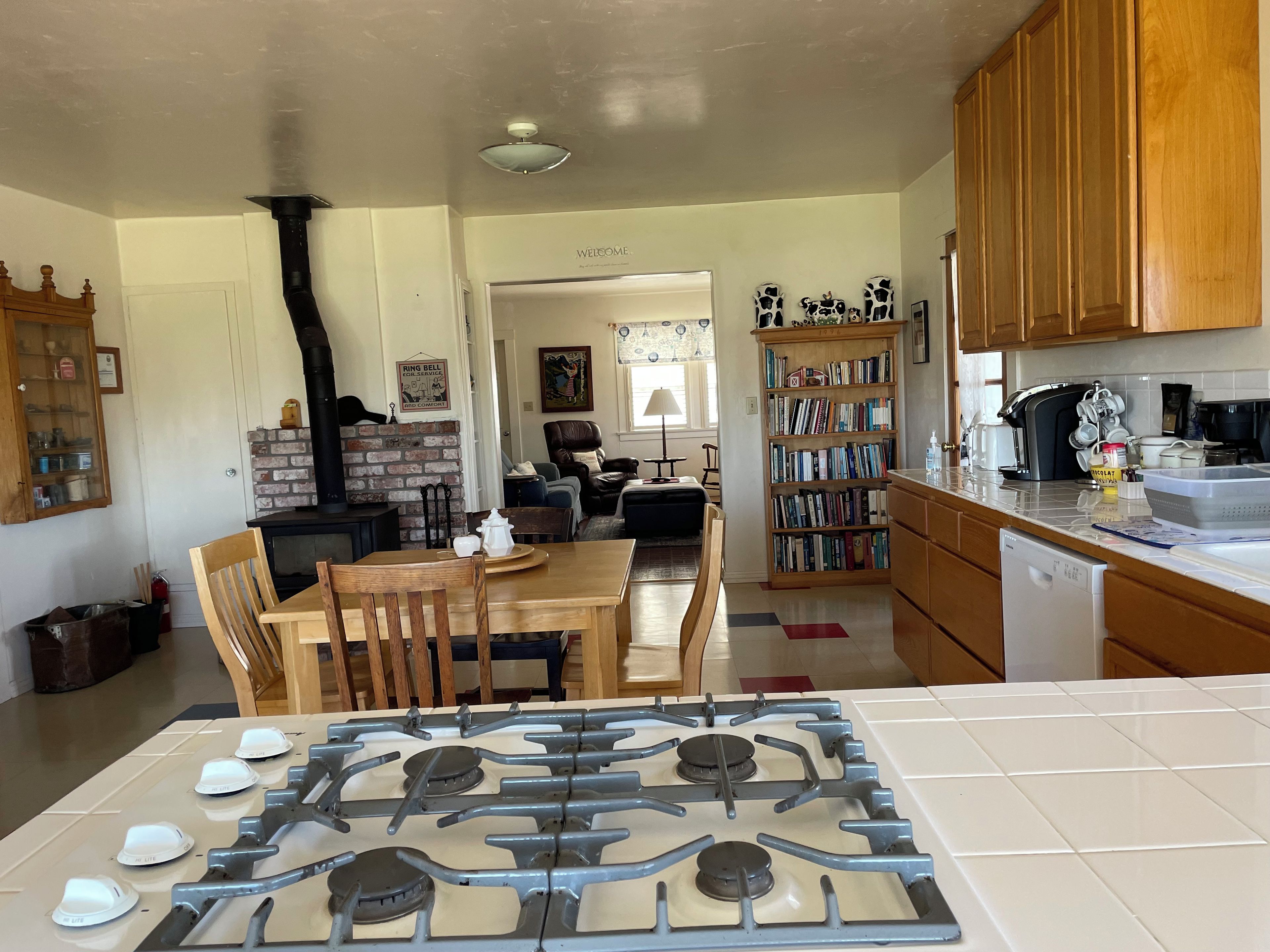A kitchen with a gas stove, wooden cabinets, and a brick wall.