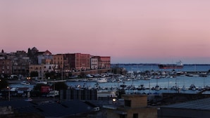 A harbor with boats, a large ship, and buildings along the waterfront. - B&B Binario Uno (Taranto)