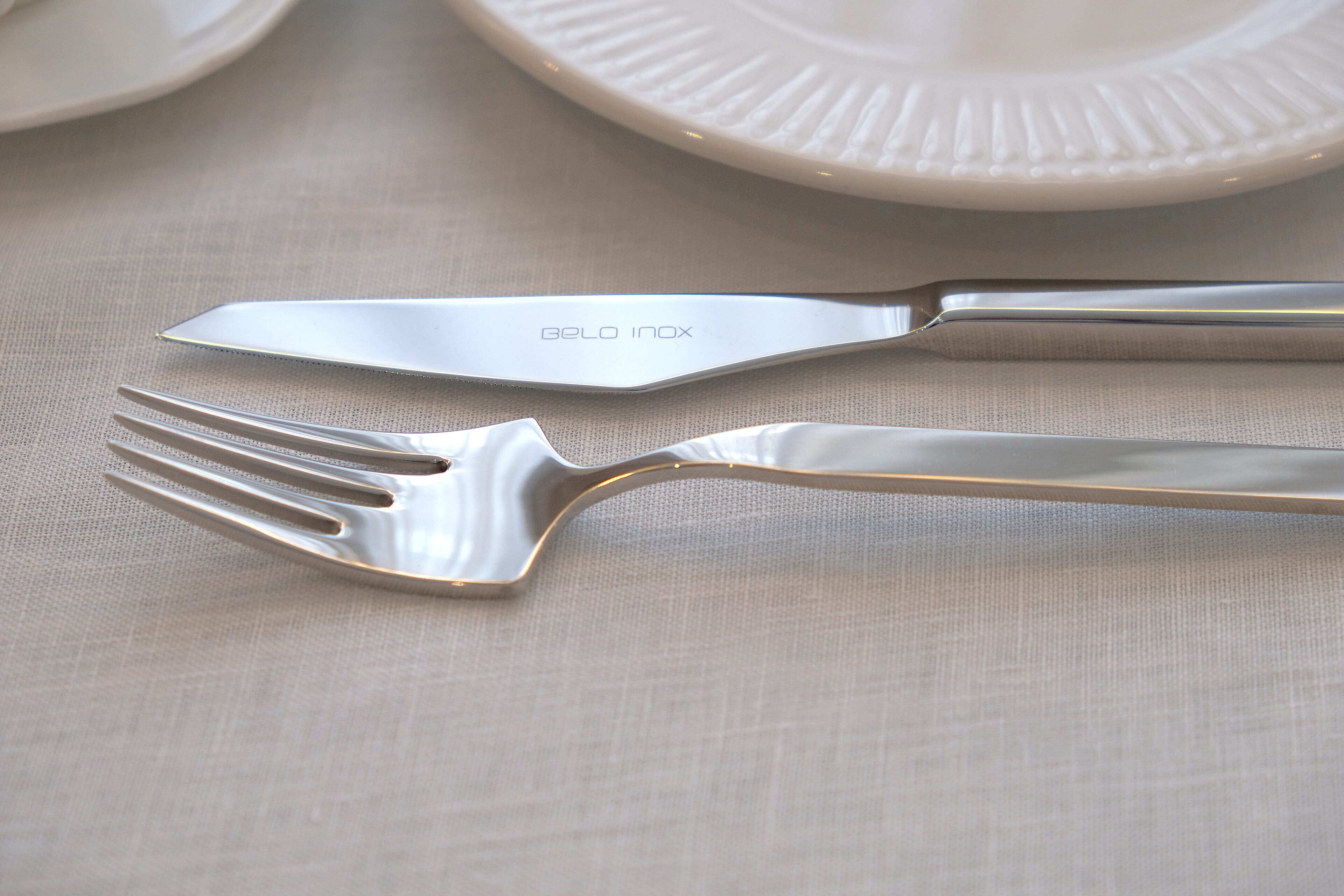 Una mise en place con tenedor y cuchillo sobre un mantel con textura.