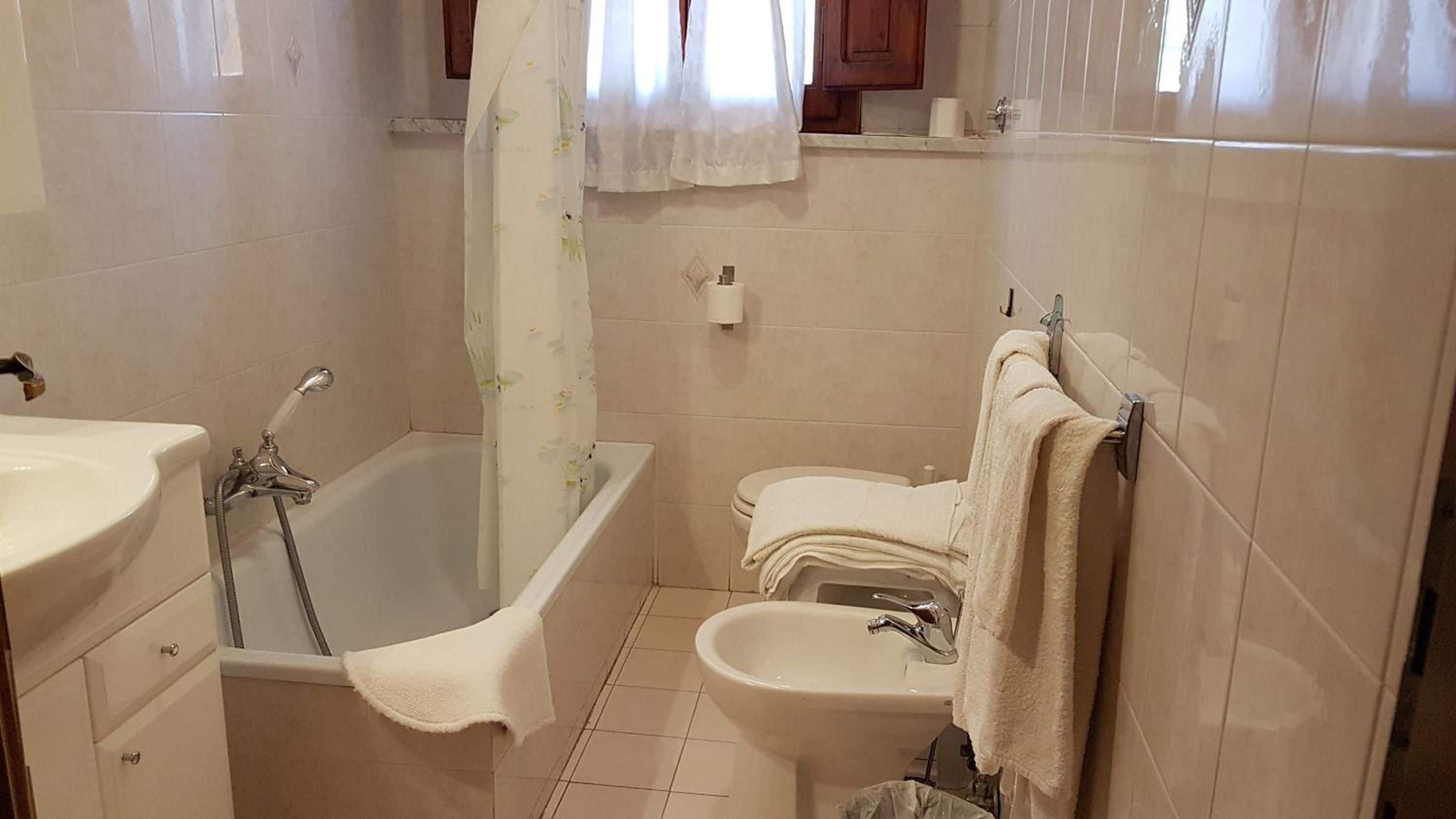 A bathroom with a bathtub, toilet, and sink.