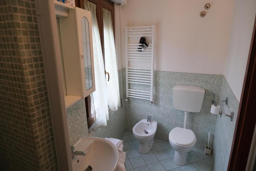 Ein Badezimmer mit Waschbecken, Bidet, Toilette und Handtuchhalter.