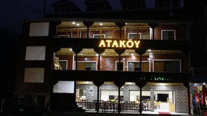 Un immeuble avec une enseigne indiquant « ATAKOY » et plusieurs étages dotés de fenêtres et de balcons visibles.