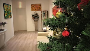 Un saló amb un arbre de Nadal, un sofà, una taula de centre i una llar de foc.
