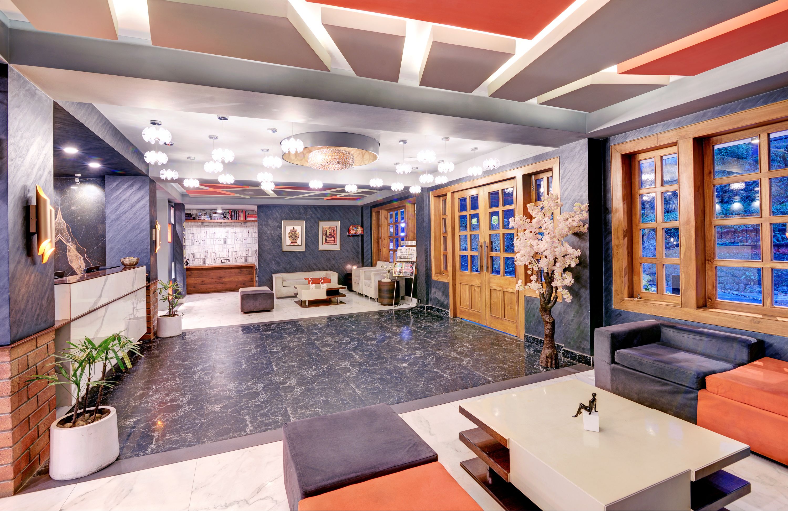 Een moderne lobby met een marmeren vloer, zithoeken en een receptiebalie.