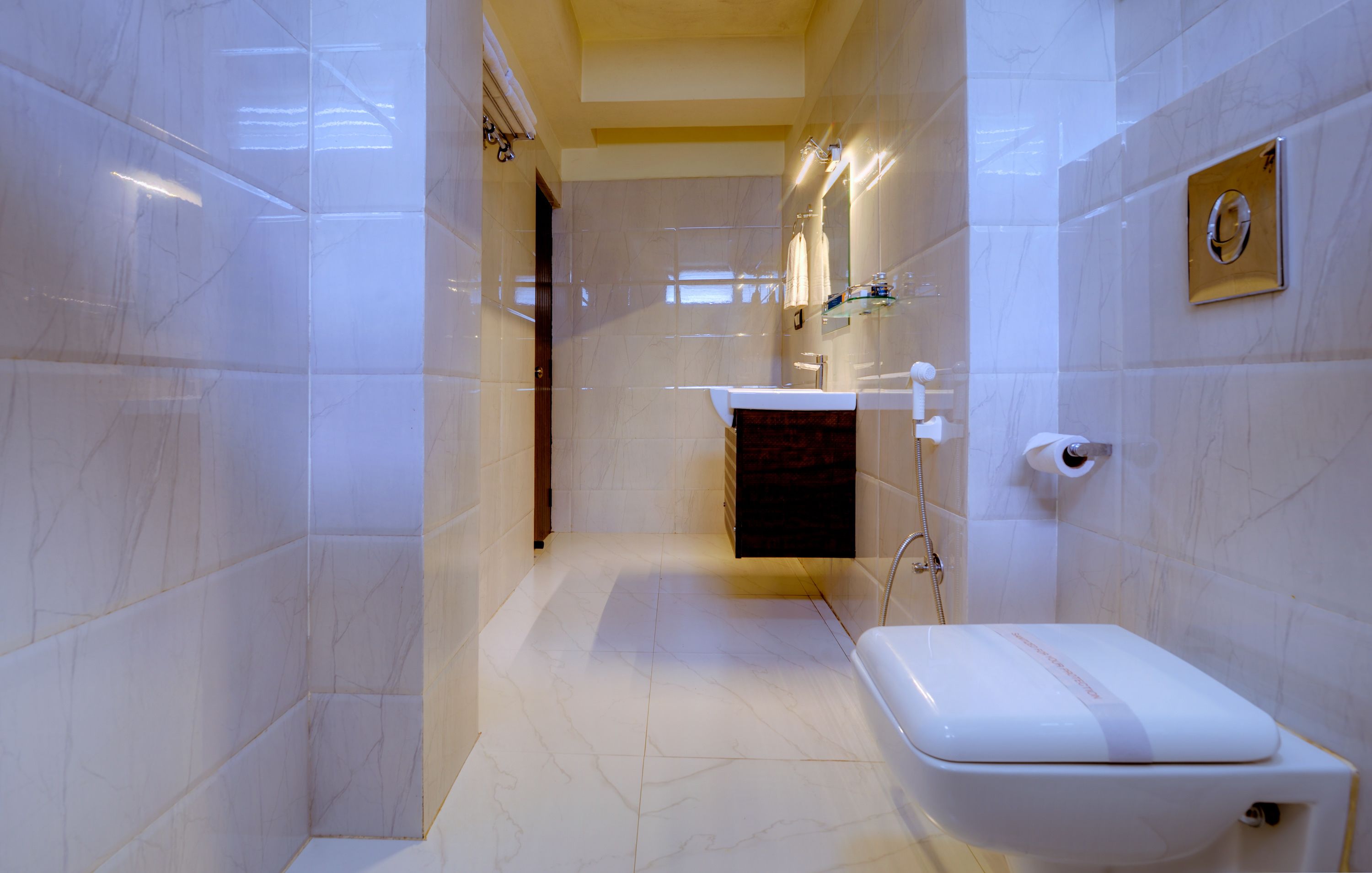 A modern bathroom with a white toilet, a sink, and a shower area.