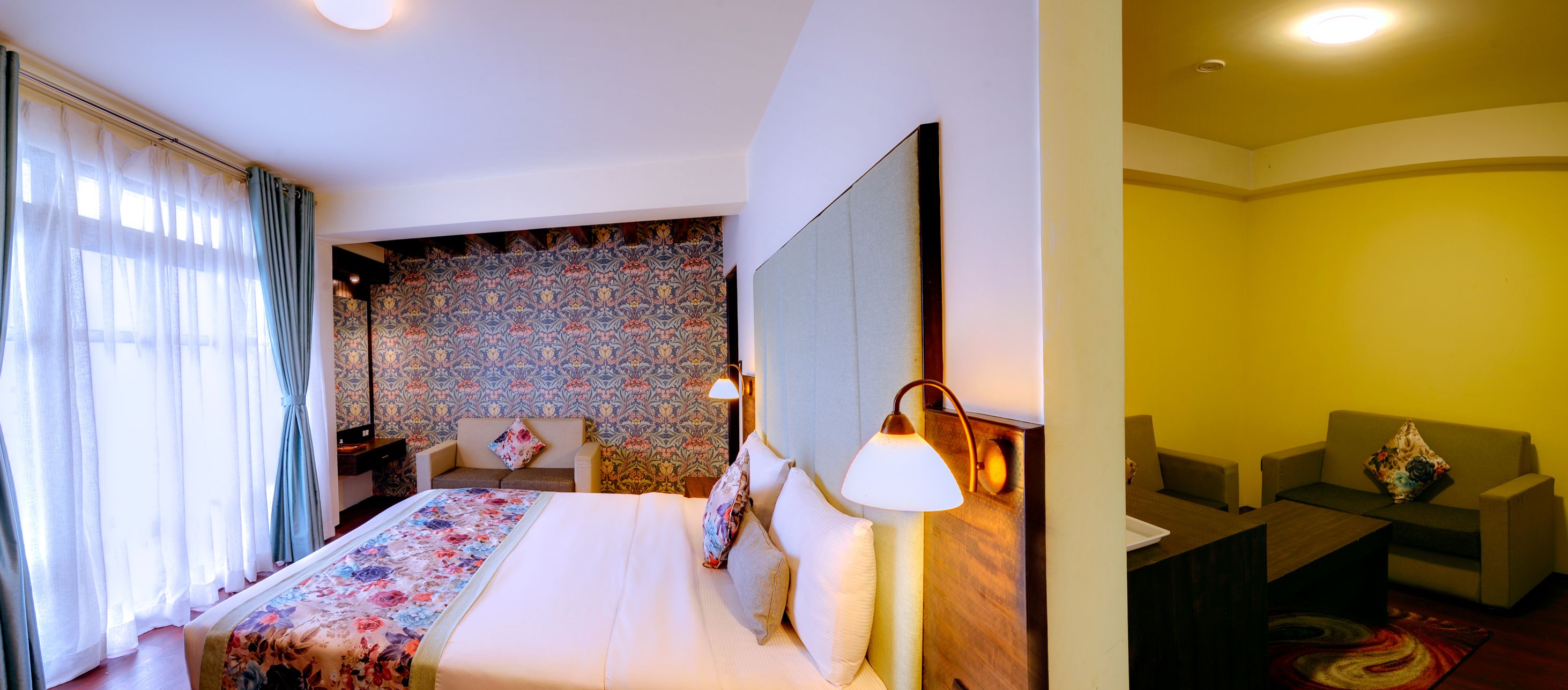 Una camera d'hotel con un letto, un comodino, una scrivania e una sedia.