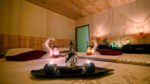 Una habitación con dos camas, una estatua de Buda y una bandeja con objetos.