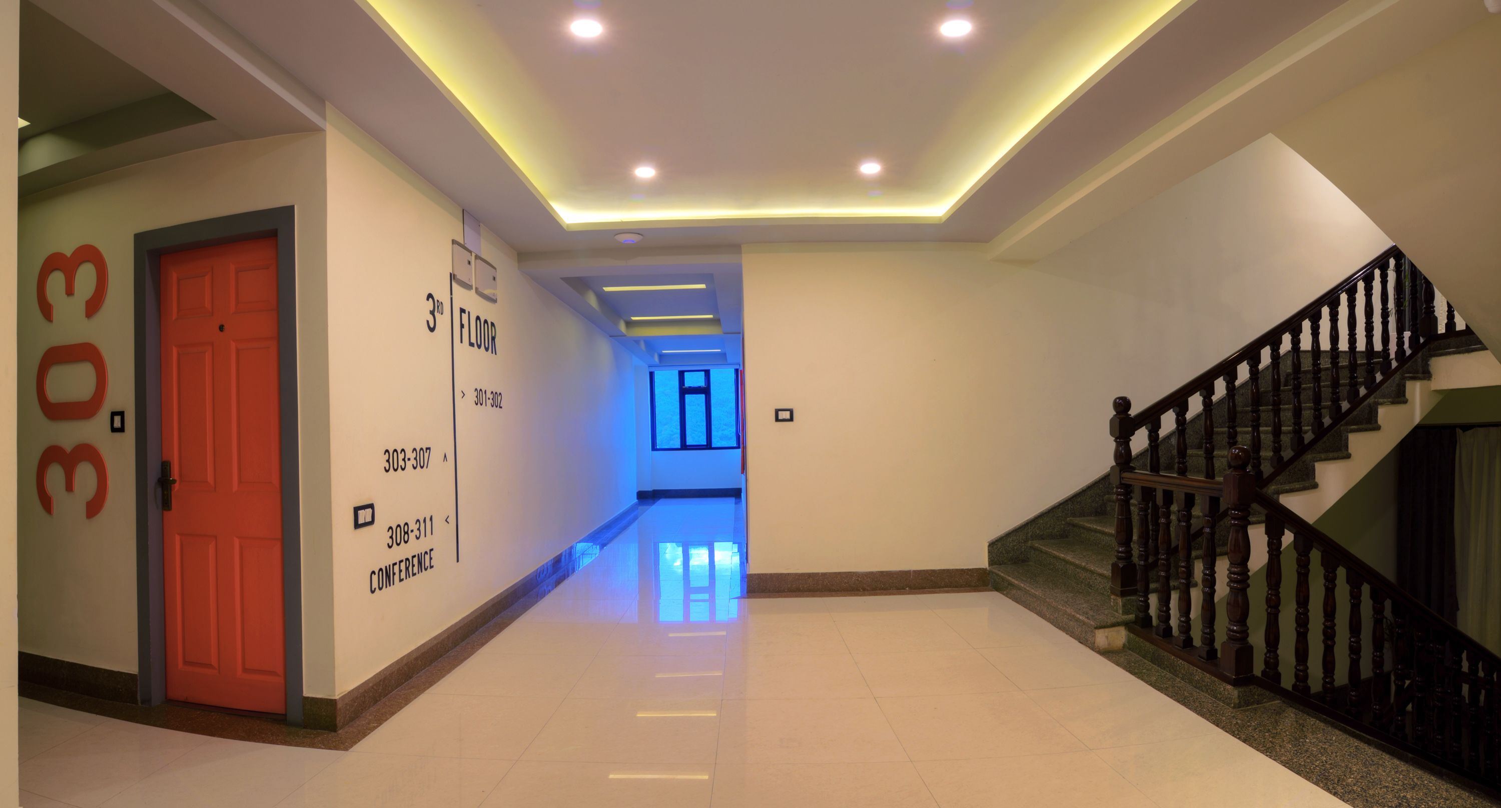 A hallway with a red door, a staircase, and a conference room sign.