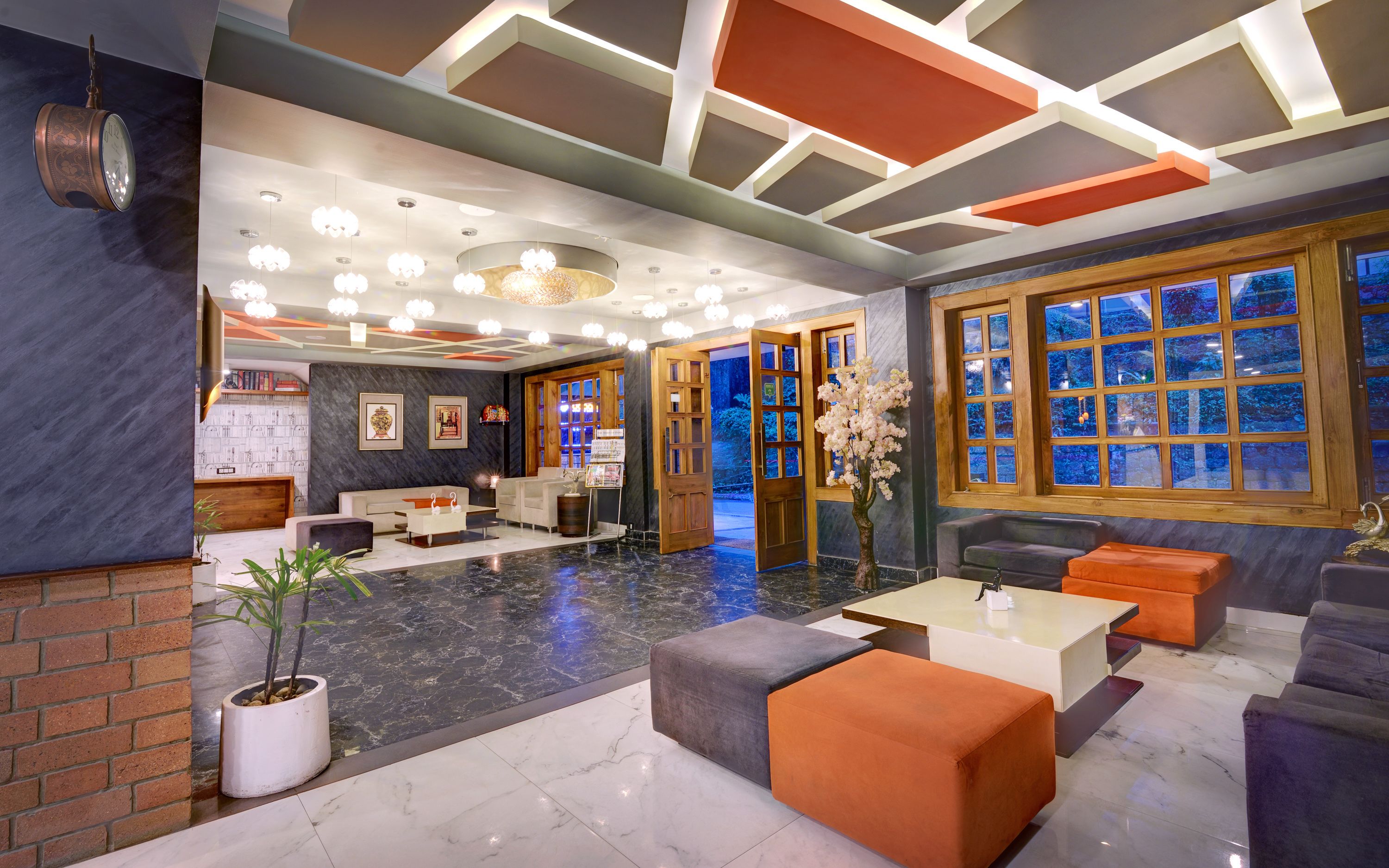 Una hall moderna con pavimento in marmo, una reception, aree relax e ampie finestre con vista.