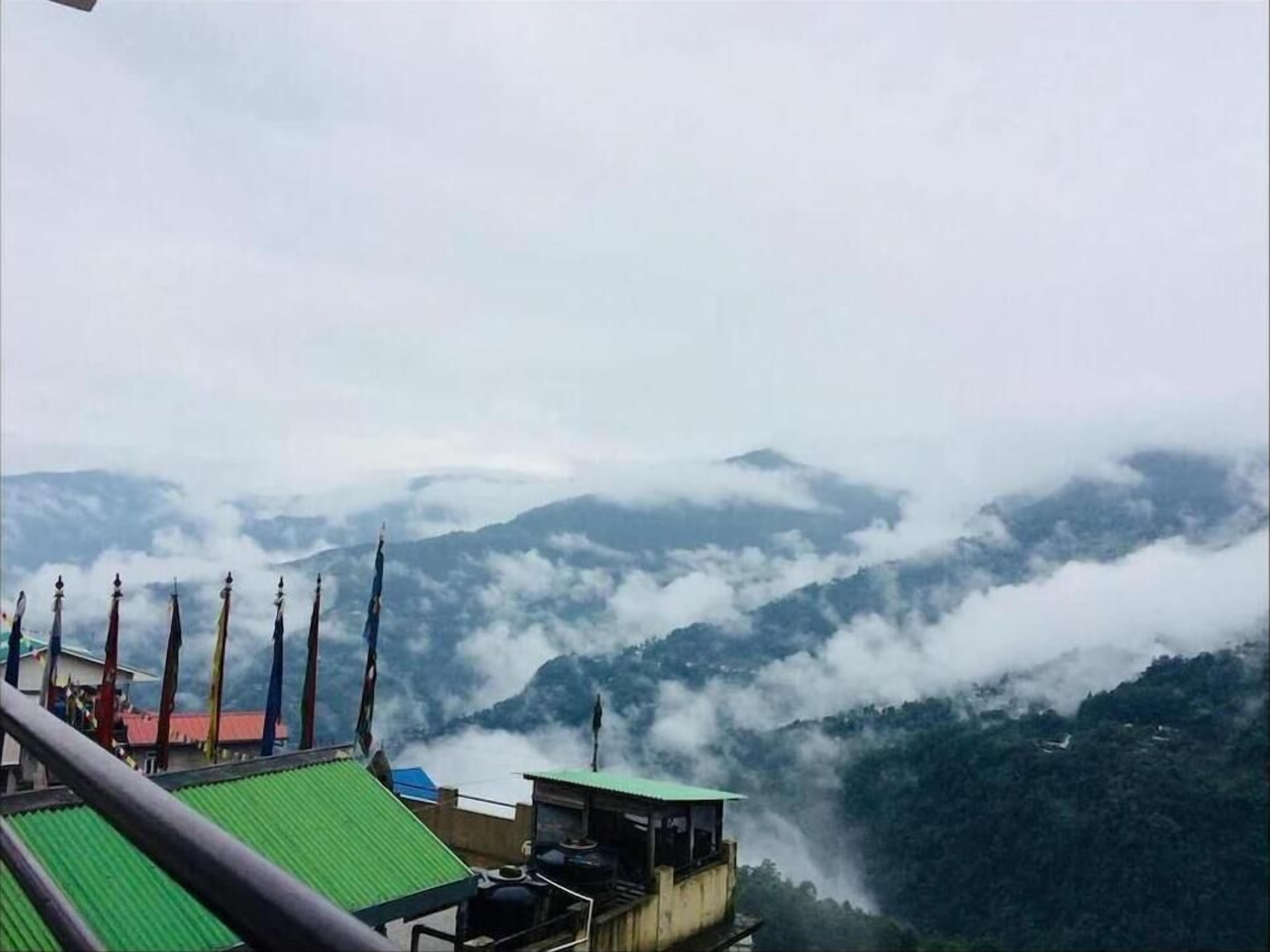 A view of a mountainous landscape with clouds below.
