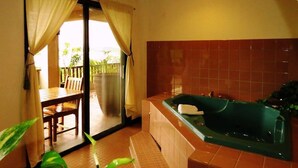 A bathroom with a bathtub, a toilet, and a shower area. - Cliffside View Hotel (Meyungs)