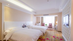 A hotel room with two beds, a TV, a desk, and a chair. - Guilin Manhattan Hotel North Station (Guilin)