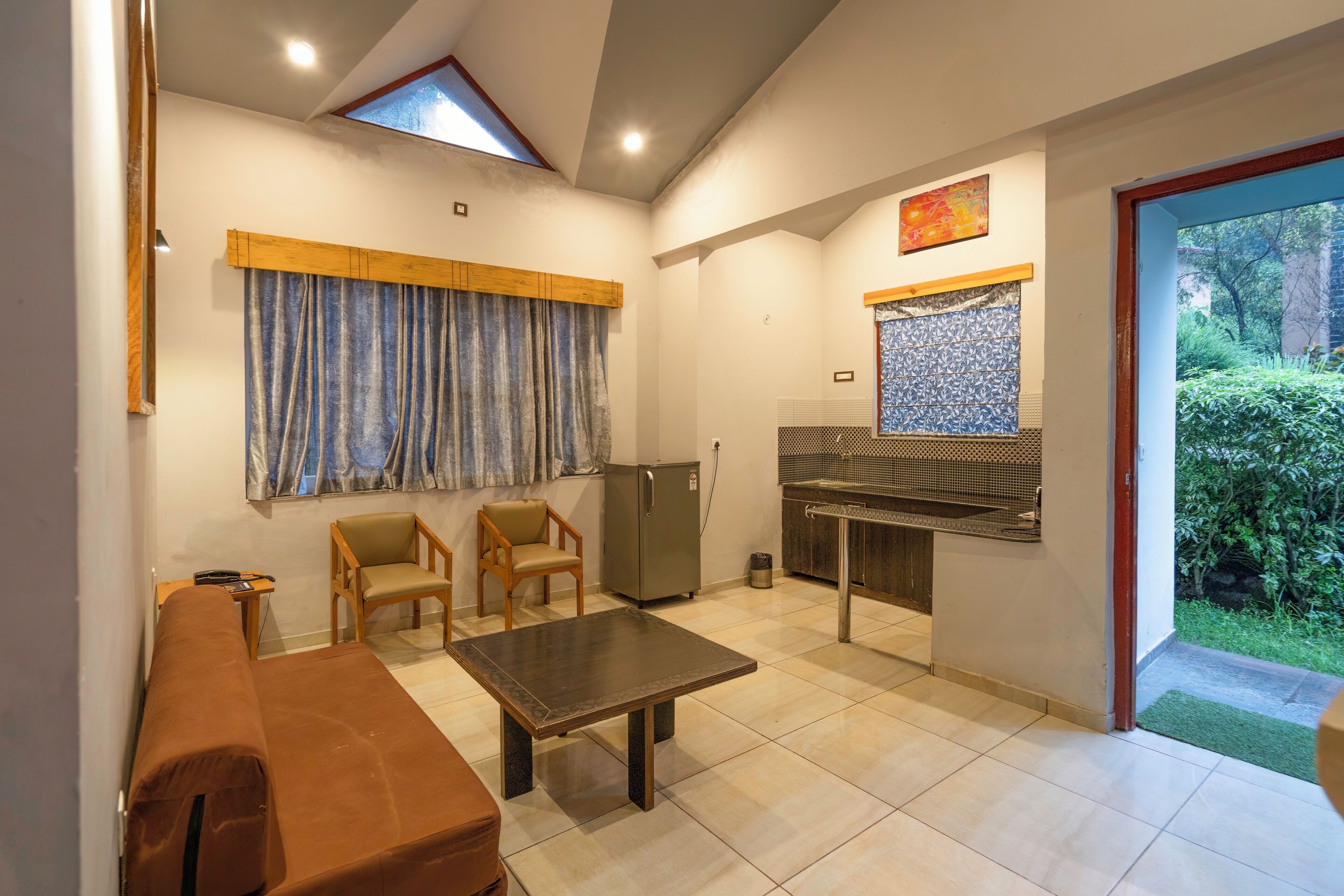 A compact living space with a kitchenette, a dining area, and a small seating area.