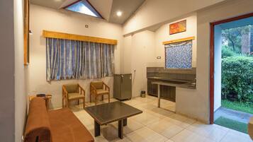 A compact living space with a kitchenette, a dining area, and a small seating area.