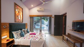 A modern bedroom with a bed, a wooden bench, a television, and a large window. - LaTigre Resort (Salt)
