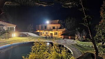 Una piscina techada, una piscina al aire libre, sombrillas