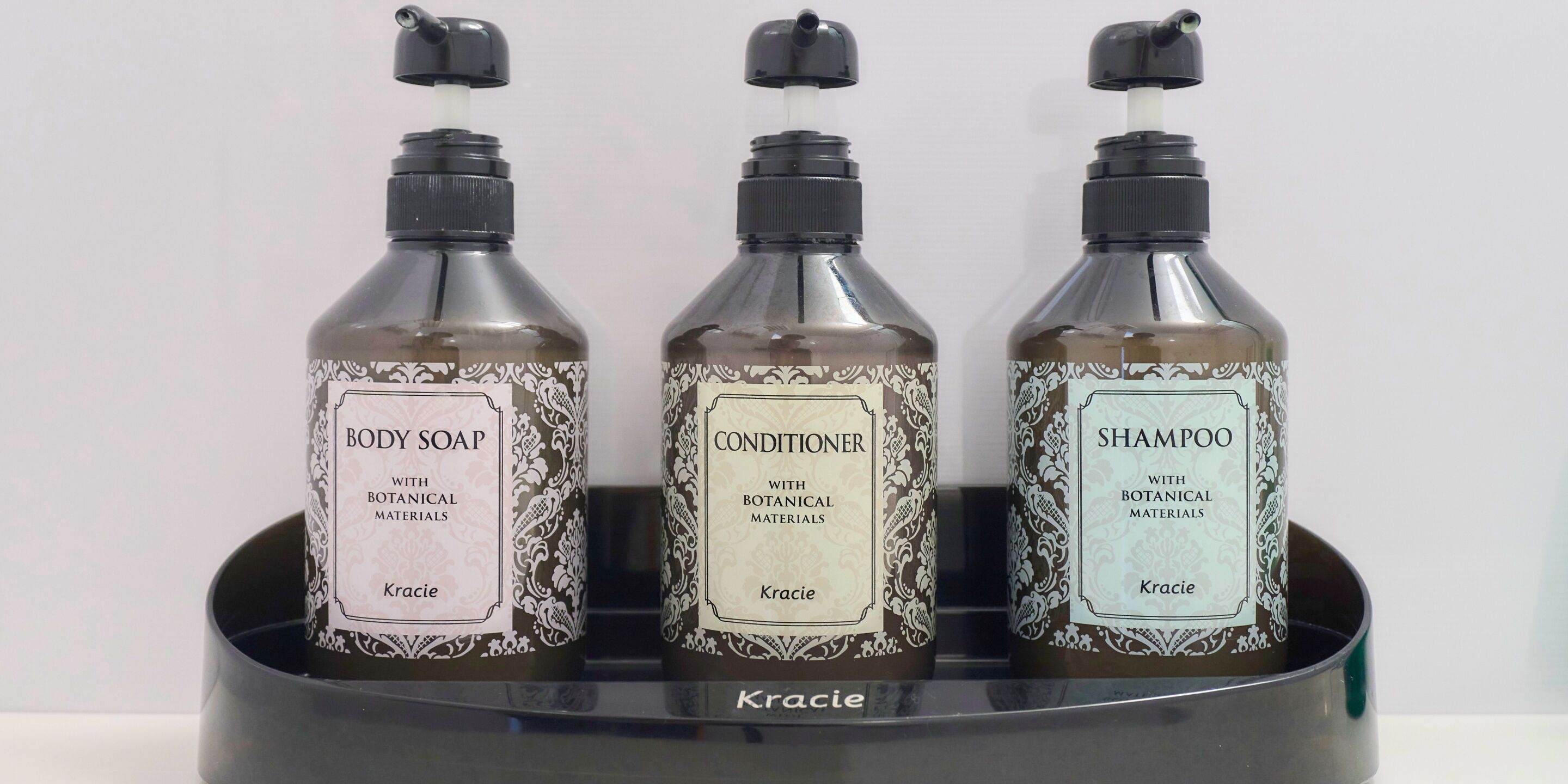 Three bottles of Kracie body care products in a black holder.