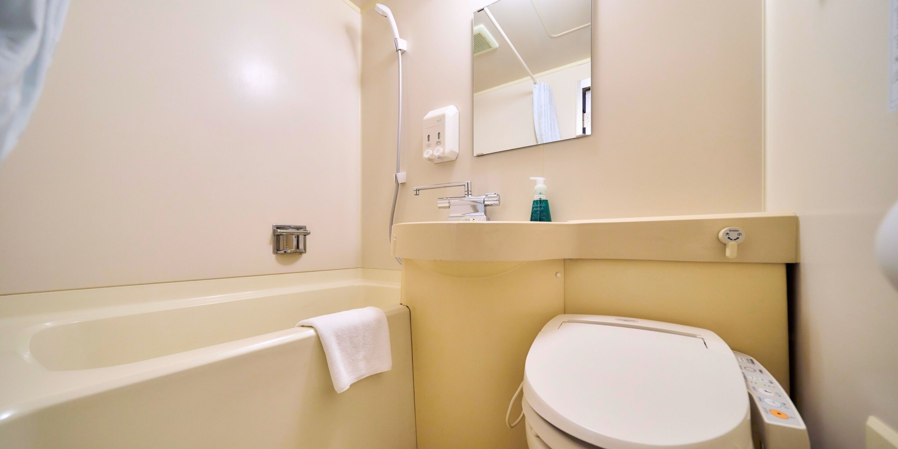 A bathroom with a bathtub, toilet, sink, and a mirror.