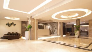 Eine moderne Lobby mit Empfangstresen, Sitzgelegenheiten und Zierpflanzen.