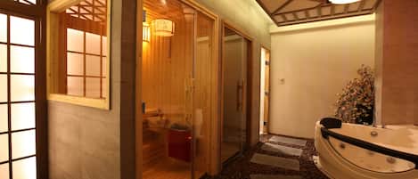 A traditional Japanese-style bathroom with a wooden interior, a soaking tub, and a stone pathway leading to the tub.