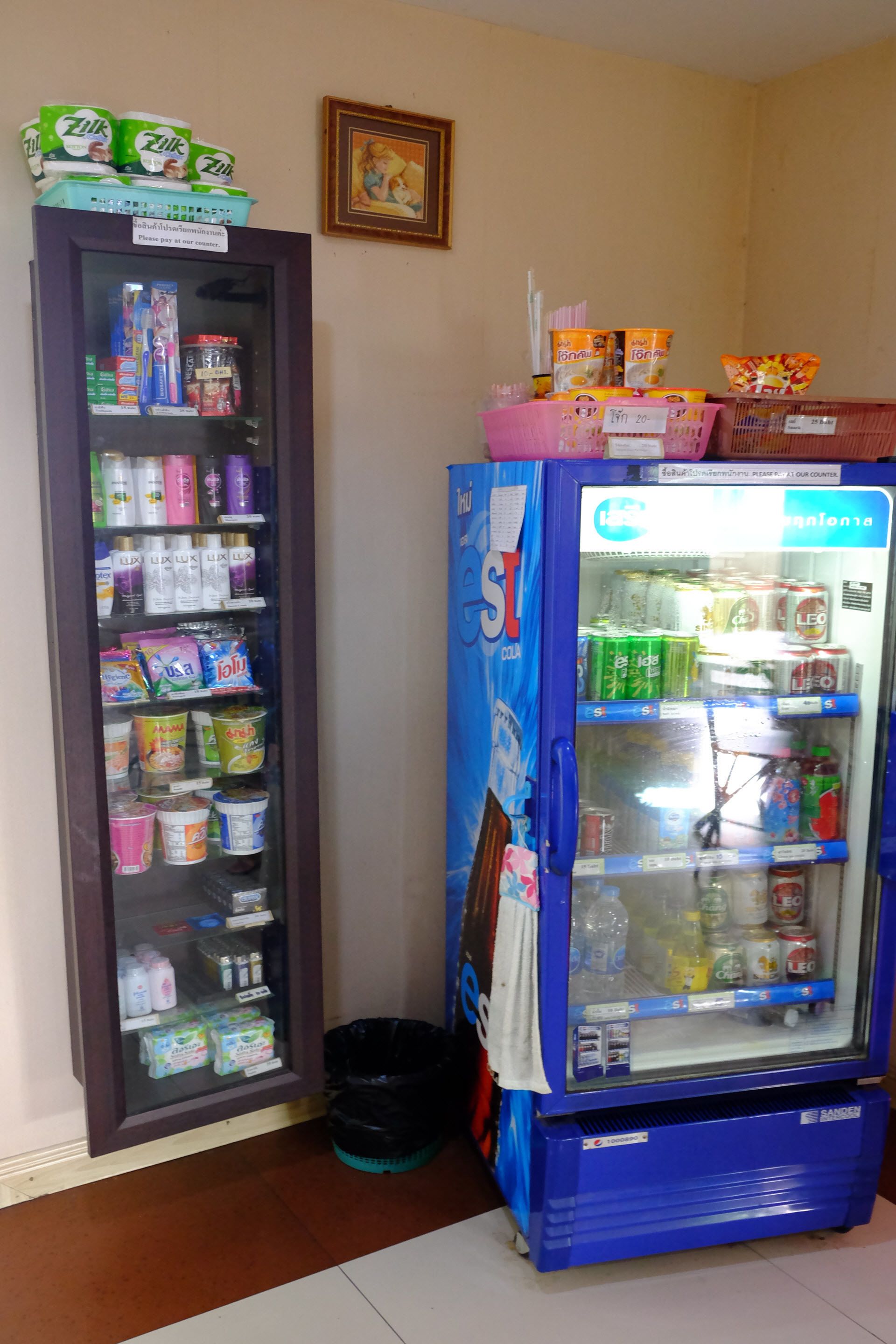 A vending machine stocked with beverages and snacks, and a refrigerated display case with various food items.