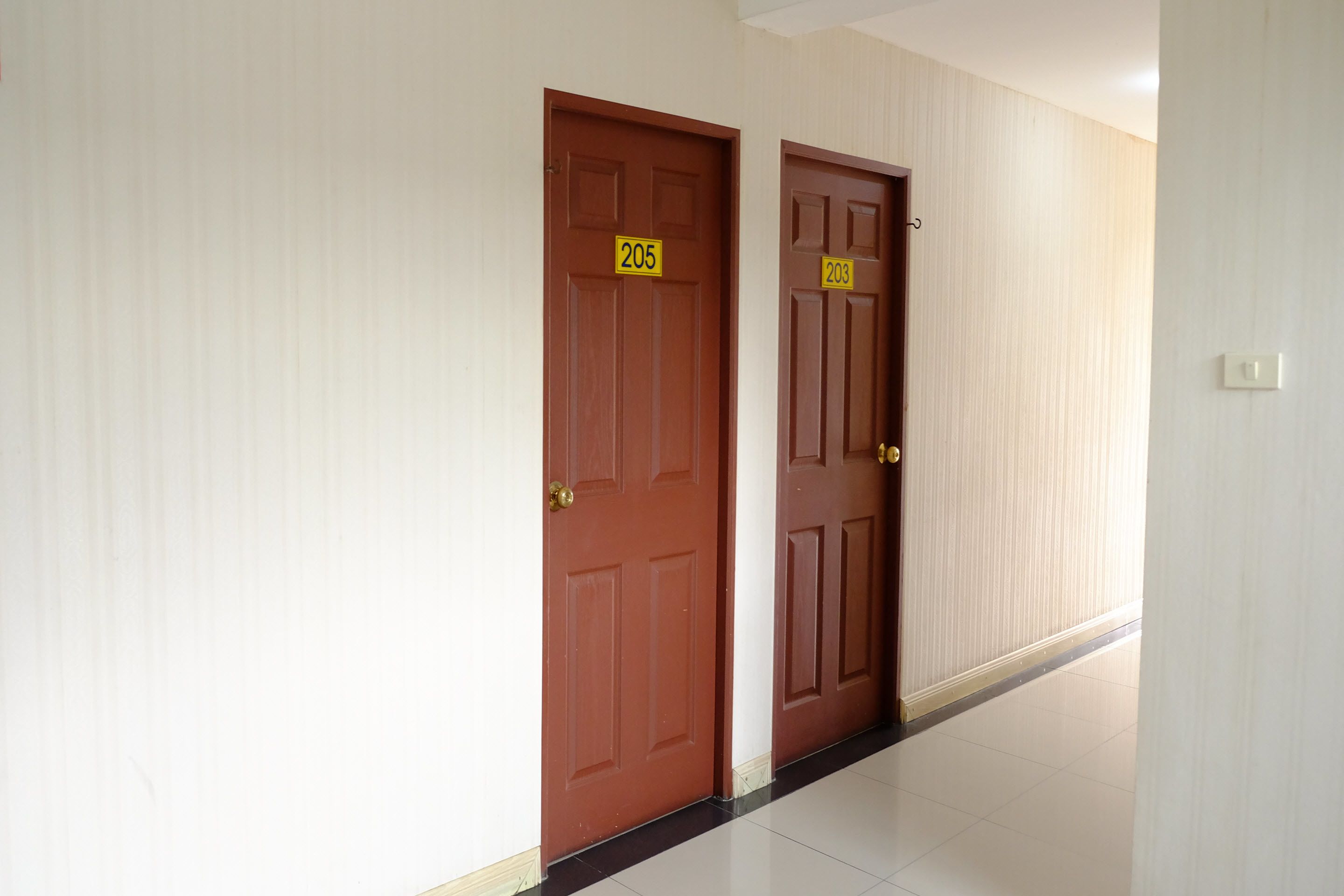 A hallway with two wooden doors, each marked with a number.