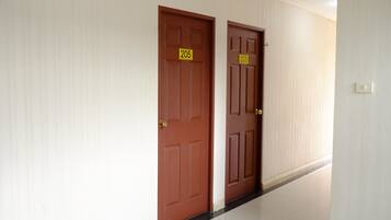 A hallway with two wooden doors, each marked with a number.