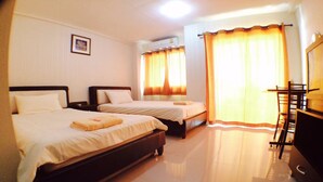 Habitación de hotel con dos camas, un escritorio y una silla.