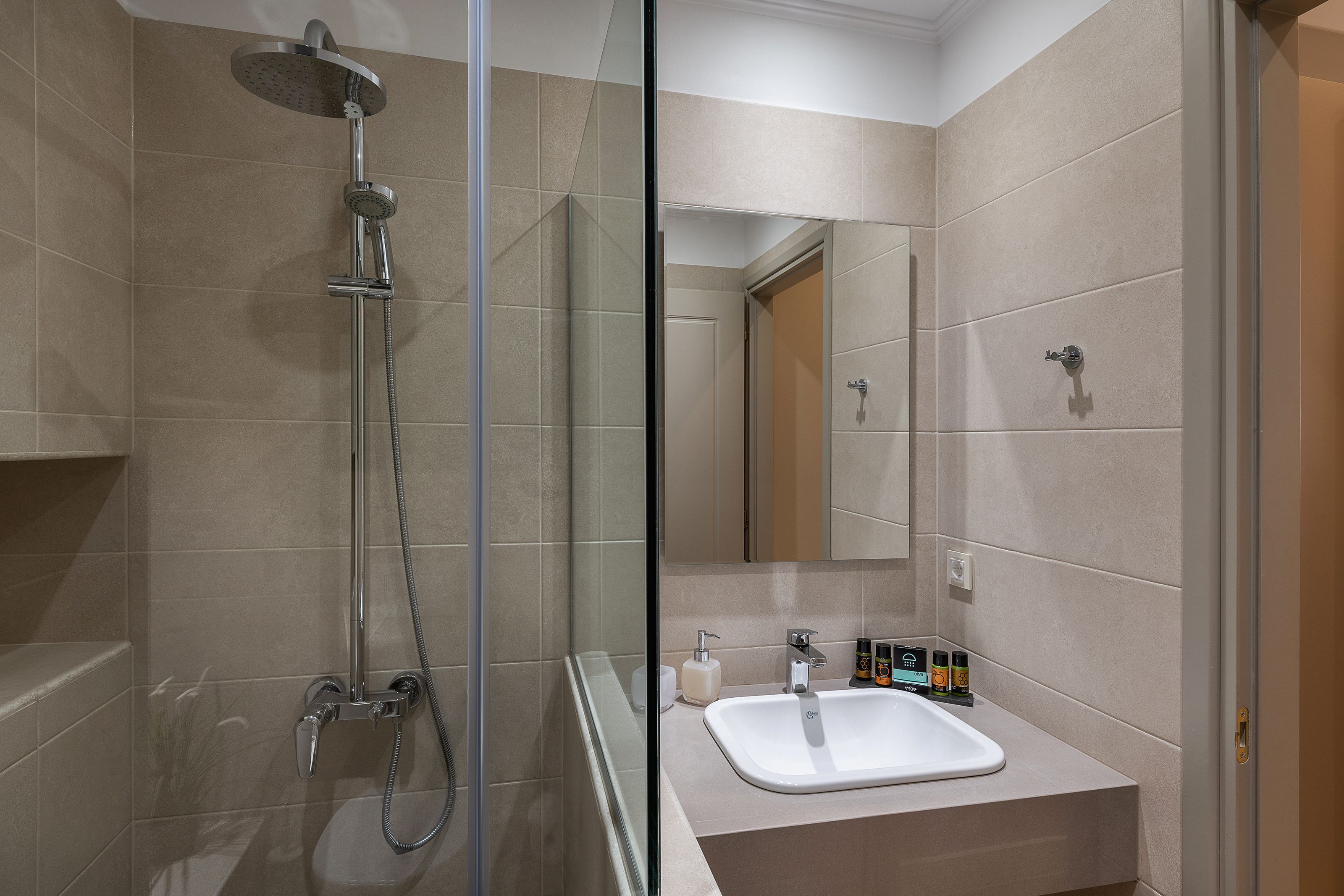 Un baño moderno con ducha de vidrio, lavabo con espejo y retrete.