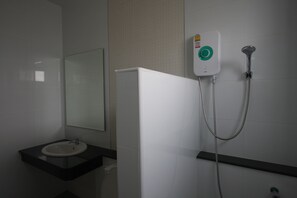 A bathroom with a white sink, a mirror, and a shower unit with a control panel. - Rongsang Resort (Nong Khae)