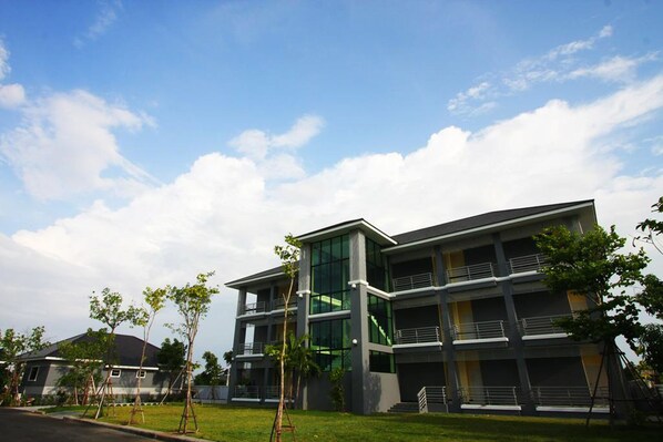 A modern multi-story building with a glass facade, multiple balconies, and a flat roof. - Rongsang Resort (Nong Khae)