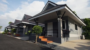 A modern residential building with a covered porch, a small tree, and a staircase leading to the entrance. - Rongsang Resort (Nong Khae)