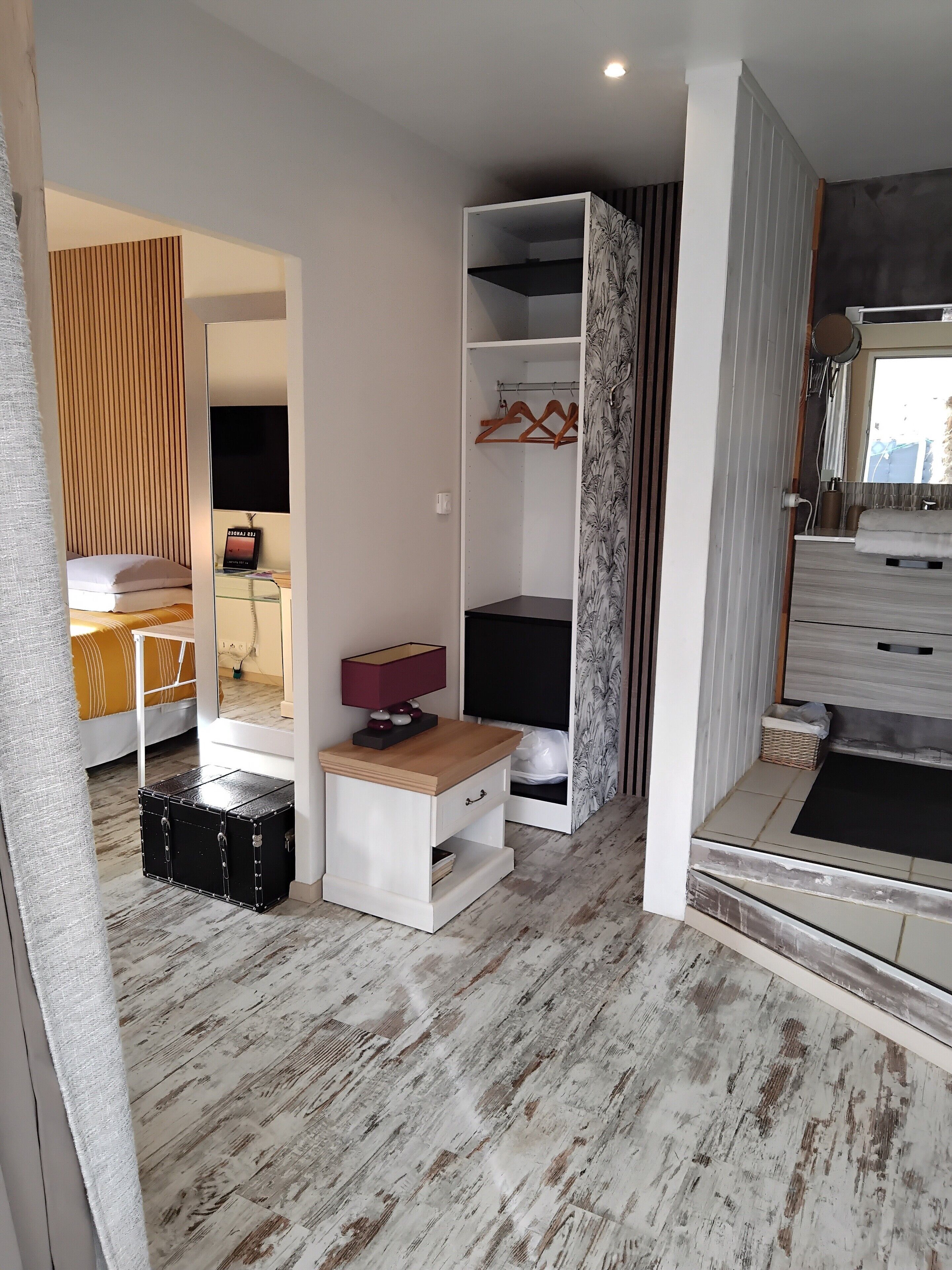 Een moderne slaapkamer met een bed, nachtkastje en een kledingkast.