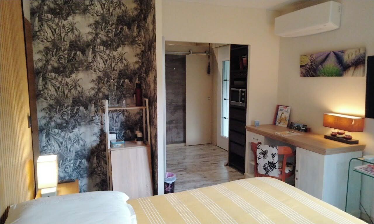 Una camera da letto con un letto, una scrivania, una sedia e un armadio.
