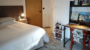 Une chambre à coucher avec un lit, une table de chevet, une lampe et une porte en bois.