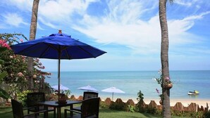 A patio with a table and chairs, a blue umbrella, and a view of the ocean. - 5 Bedroom Beachfront Villa SDV100-By Samui Dream Villas (Koh Samui)