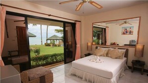 A bedroom with a large bed, a view of the sea, a ceiling fan, and a small table with a lamp. - 5 Bedroom Beachfront Villa SDV100-By Samui Dream Villas (Koh Samui)