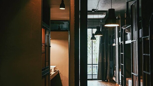 A narrow hallway with wooden cabinets and pendant lighting. - Cloudy Hostel (Bangkok)