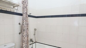 A bathroom with a toilet, bathtub, and shower curtain.