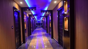 Un largo y estrecho pasillo de hotel con paredes de madera y un piso brillante y reflectante.