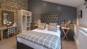 Un dormitorio con una cama grande, un armario, un escritorio y una silla.