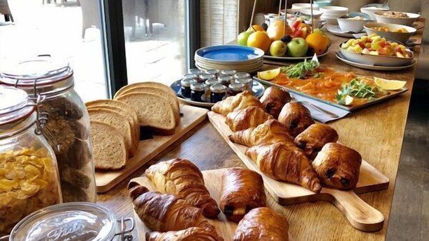 Un bufé de desayuno con croissants, pan y fruta.