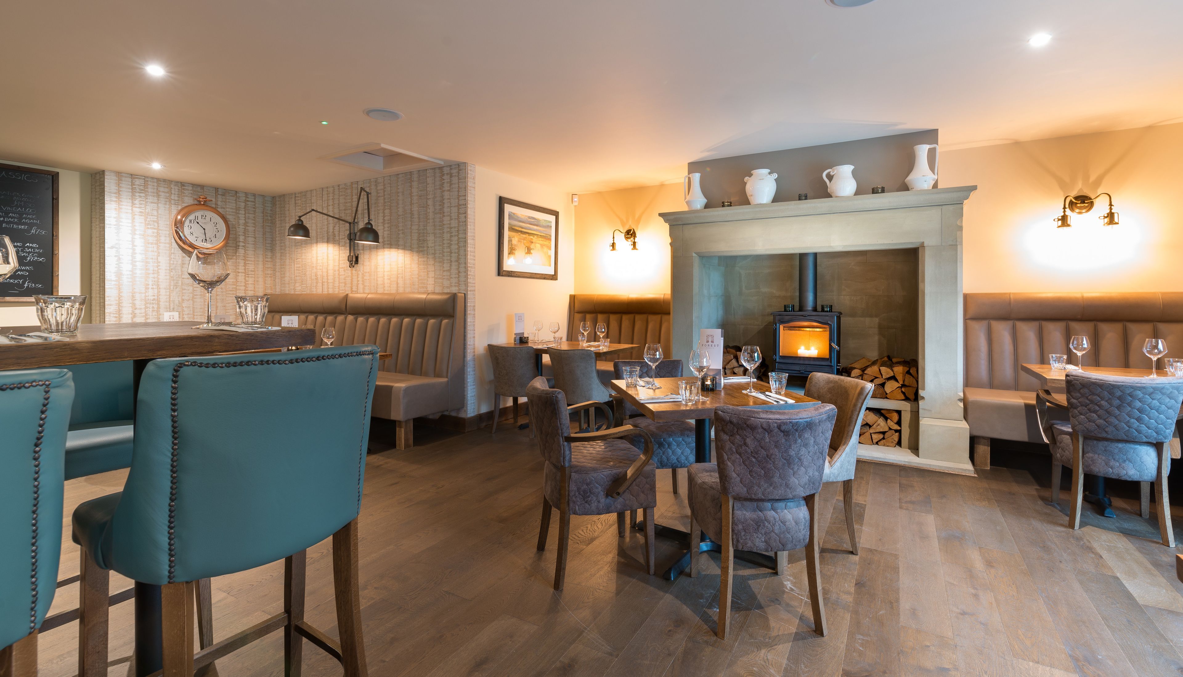 Un restaurante acogedor con muebles de madera, una chimenea y una zona de bar.