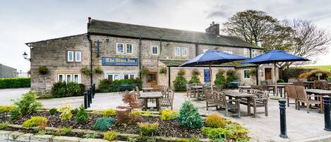 The Alma Inn with outdoor seating and a stone facade.