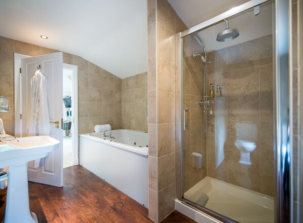 A modern bathroom with a glass-enclosed shower, a freestanding bathtub, and a white sink. - The Alma Inn (Colne)