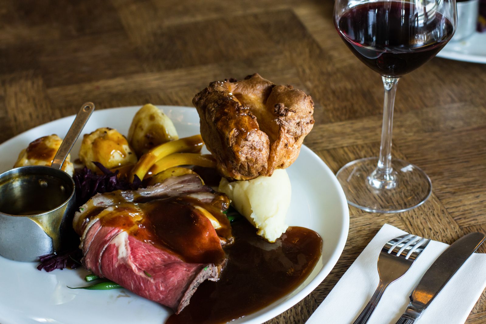 A plate of food with a glass of red wine.