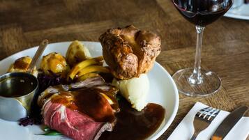 A plate of food with a glass of red wine.